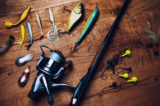 Fishing Baits And Rod Isolated On Wooden Background