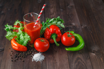 Glass of tasty tomato juice and fresh tomatoes on table