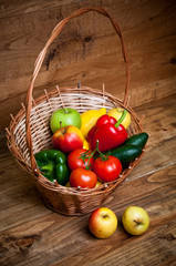 Vegetables and fruits in basket on wooden table