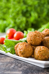 Vegetarian falafels and vegetables on a rustic wood

