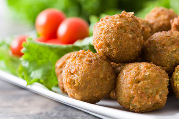 Vegetarian falafels and vegetables on a rustic wood

