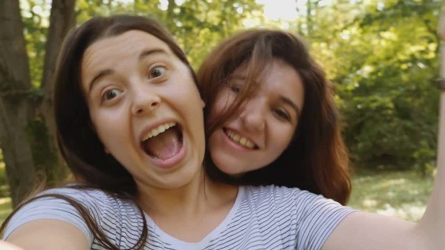 Beautiful young women taking selfie in the park