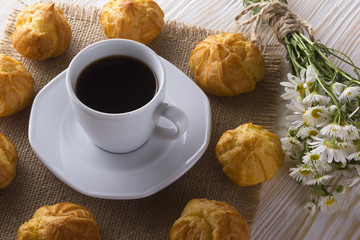 Eclair, coffee cup and charmomile.