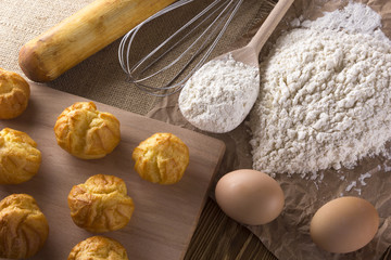 Tasty eclairs, eggs, flour and handle mixer.