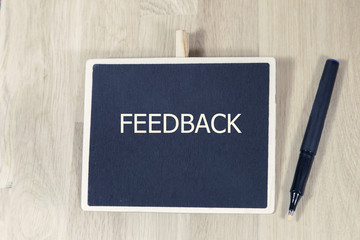 The text FEEDBACK behind torn paper