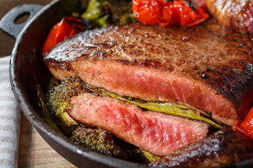 Beef steak with vegetables on a cast-iron frying pan