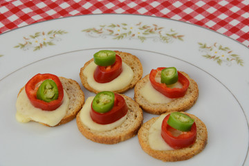 Appetizers of melba toast, melted mozzarella cheese, jalapeno peppers and hot peppers