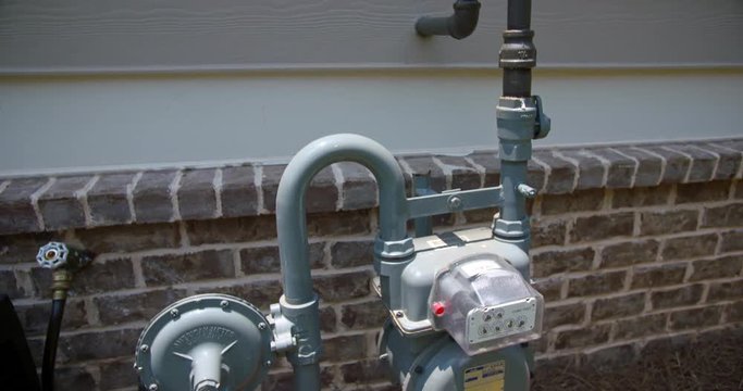 Exterior Gas Meter Medium Lowering. lowering shot on a close up of a residential home gas meter on the side
