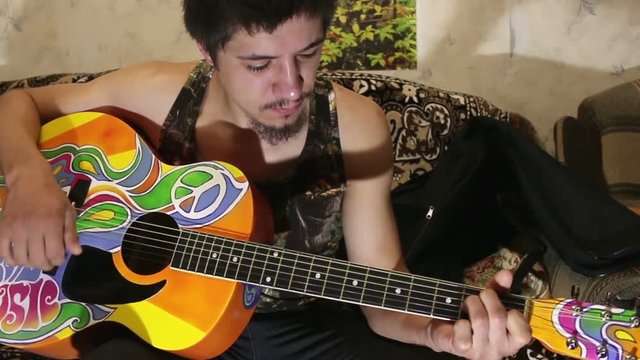 Guy plays guitar hippie style