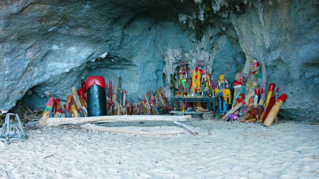 Video UltraHD - Hand-carved and painted, wooden phalli, lining a cave's walls around a Buddhist shrine in Princess Cave on a Beach in southern Thailand.
