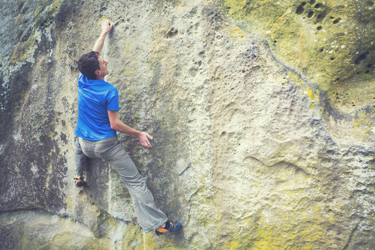 Climber is bouldering on the rocks.