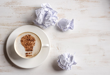 Lightbulb made of cinnamon in coffee. Great concept with crumpled office paper, light bulb and...