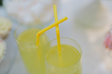 two glasses of refreshing lemonade with yellow tubes