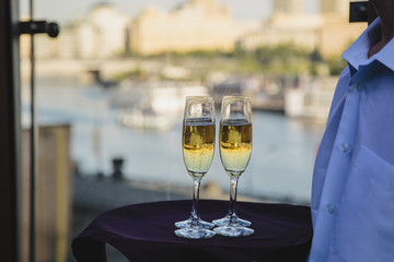 glasses of white wine, reflecting the city skyline behind, on th