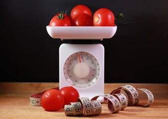 Several red tomatoes on a kitchen scale
