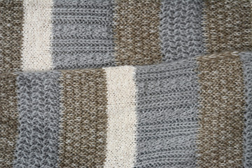 Close up of knitted gray beige shawl scarf