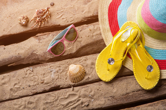 Flips flops and seashells. Woman's beach hat and sunglasses. Relax during your trip. Leave all worries behind.