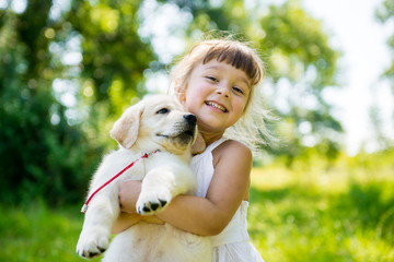 Little girl with a Golden retriever puppy