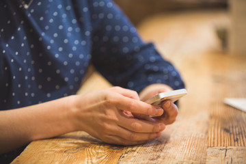 Close up photo of beautiful young woman sitting cozy at wooden table. Girl using  touch screen...