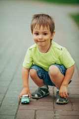 little boy playing with toy car