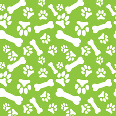 Seamless pattern with white dog paw prints and bones on a green background
