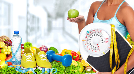 Woman hands with scales and fruits.