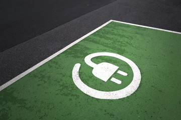 Empty electric vehicle parking station sign background on asphalt floor.