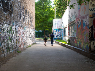 Tourists walk next to graffiti.