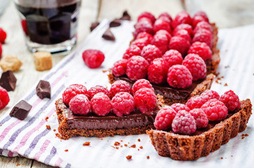 chocolate tart with chocolate filling and fresh raspberries - obrazy, fototapety, plakaty