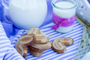 milk carafe and cookies on a table purple striped napkin