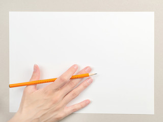 Hand with pencil on blank paper sheet