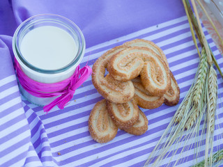 milk carafe and cookies on a table purple striped napkin