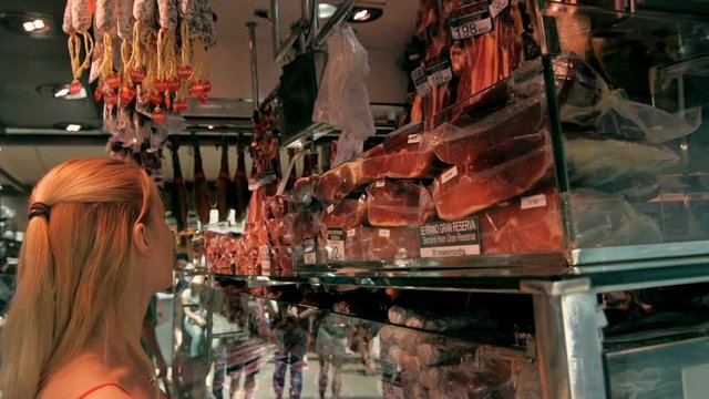beautiful girl choose jamon on market