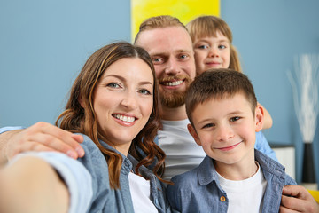 Happy family taking selfie on blue wall background