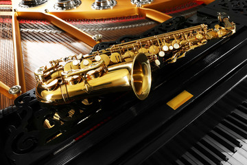 Saxophone lying on the piano, close up