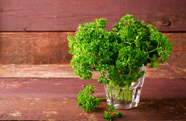 Fresh organic green curly parsley in a glass