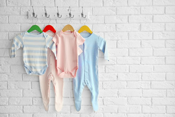 Colorful set of baby romper on brick wall