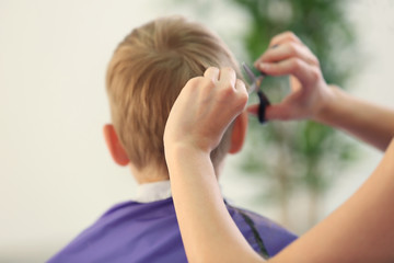 Hairdresser's hands making hairstyle to child