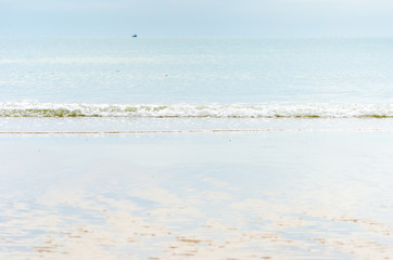 Landscape view of sea and sand beach with reflection of blue sky