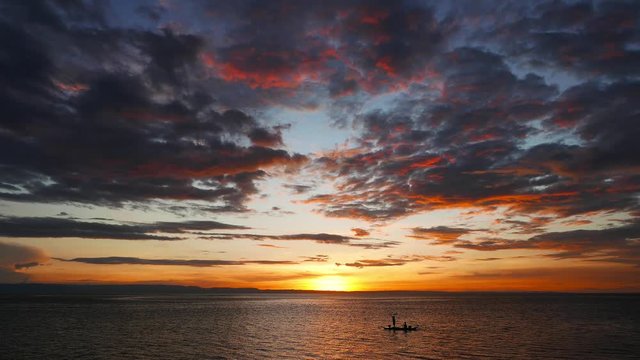 A sunset video from Camotes Island shores with fiery clouds. Local fishermen can be seen going back home (in silhouette form). Presented in real time.