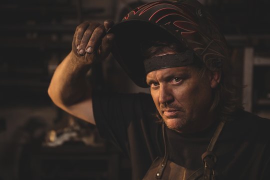Portrait of blacksmith standing in workshop