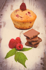 Vintage photo, Fresh baked muffins with raspberries and chocolate on wooden background, delicious dessert