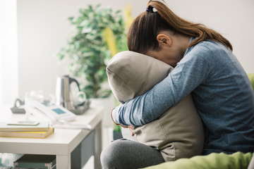 Sad woman hugging a pillow