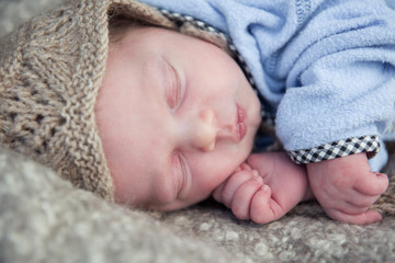 Newborn cute baby sleeping on fur blanket