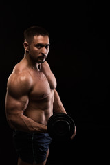 Obraz na płótnie Canvas handsome muscular bodybuilder posing on a black background