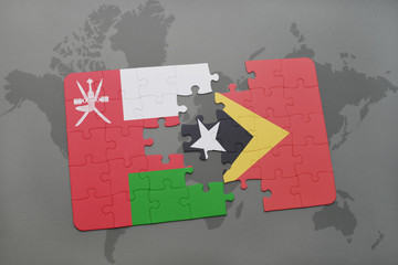 puzzle with the national flag of oman and east timor on a world map background.