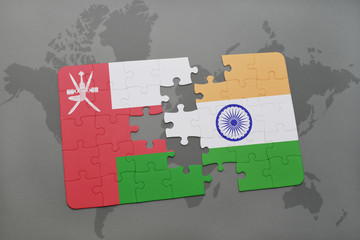 puzzle with the national flag of oman and india on a world map background.