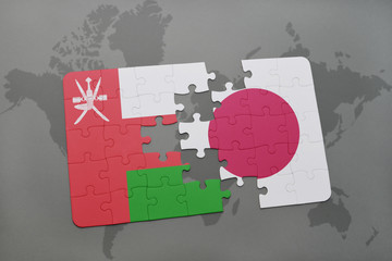 puzzle with the national flag of oman and japan on a world map background.