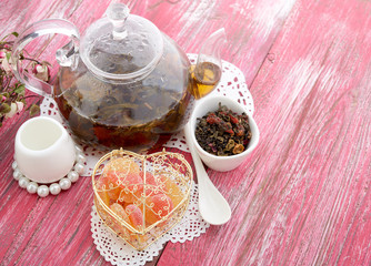 Fototapeta premium cinnamon and fruit drink in glass teapot on wooden background