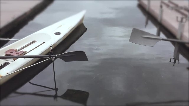 Empty rowing boat with oars floats on calm water in Lagoa Rodrigo de Freitas Lagoon, in Rio de Janeiro, Brazil